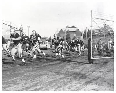 The Idaho team runs through a gate toward the locker rooms at halftime.