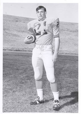 Running back Henry Boomer poses, gripping the ball in his right hand.