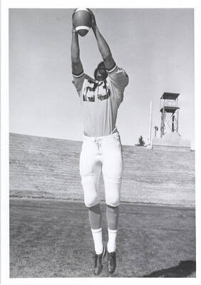 Cornerback Steve Brown poses, jumping in the air to catch a ball.