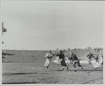 An Idaho defender attempts a tackle, only to be stiff-armed by a Cougar running back.