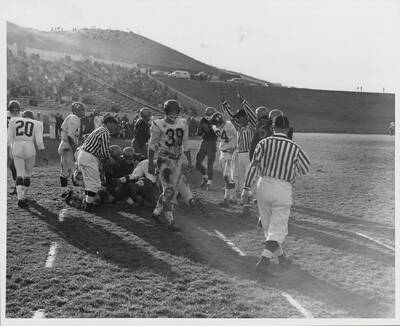 Referee signals a touchdown in front of a pileup. Idaho players celebrate.