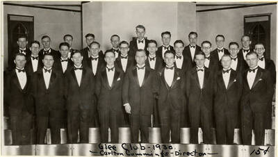 Photograph of the glee club. Caption reads 'Glee Club-1930 ~Carlton Cummings -Director~ 15 cents.' Members include: Millard Loughrey, John Soden, Kenneth Hensley, Harold Packer, Clifford Mullikin, Burnis Brigham, Reed Murdock, Frank Warner, Elton Reeves, Ray kelley, Ronald Smith, Clarence Sample, Elvon Hampton, Charles Croft, Kenneth Grabner, Harold Kirklin, William Shamberger, Harry Daubert, Irwin Tomlinson, John Jenny, Preston Ellsworth, Russell Potter, Martin Rosell, Paul Rice, Paul Parks, John Mitchell, Jack Nunemaker, Robert Vincent, Harry Walden, Clifford Hargrove, and Lionel Campbell.