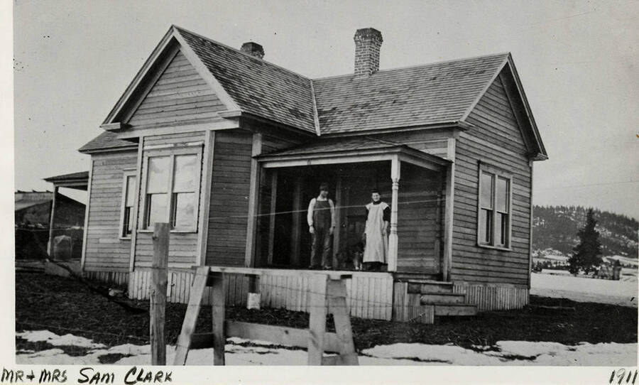 Mr. and Mrs. Sam Clark posing for a photograph on the front porch of a house.  The photograph was taken in 1911.