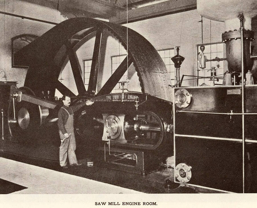 A photograph of an employee with the engine in the engine room at the sawmill.