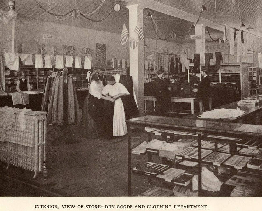 A photograph of employees and customers inside the dry goods and clothing department of the Potlatch Mercantile Company.