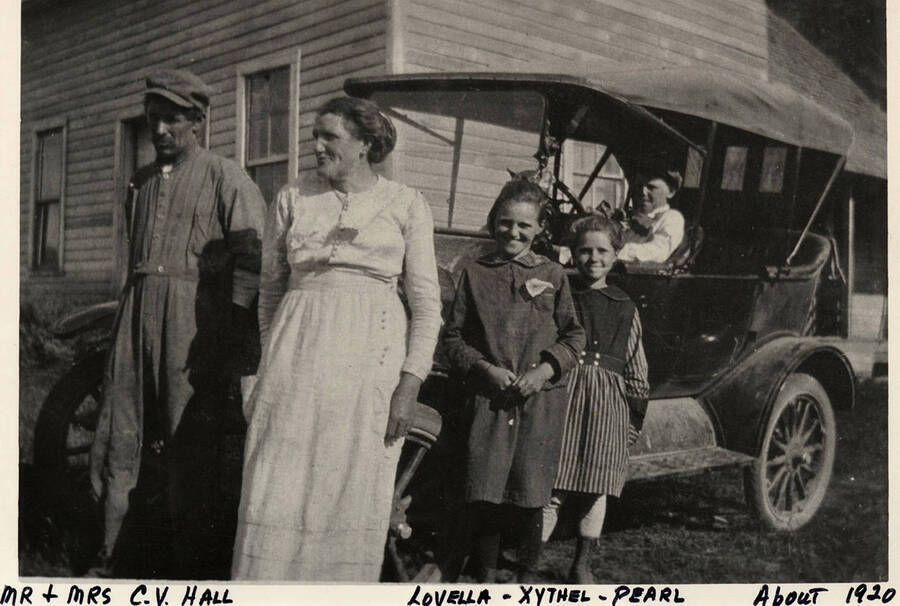 Mr and Mrs. C. V. Hall and their children Lovella, Xythel, and Pearl posing with a car outside of a house in Deep Creek. Photograph taken around 1920.