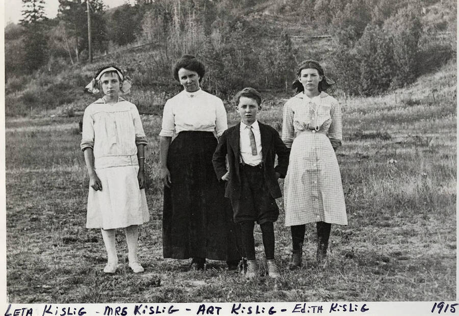 A photograph of Leta Kislig, Mrs. Kislig, Art Kislig, and Edith Kislig posing in front of a hill.