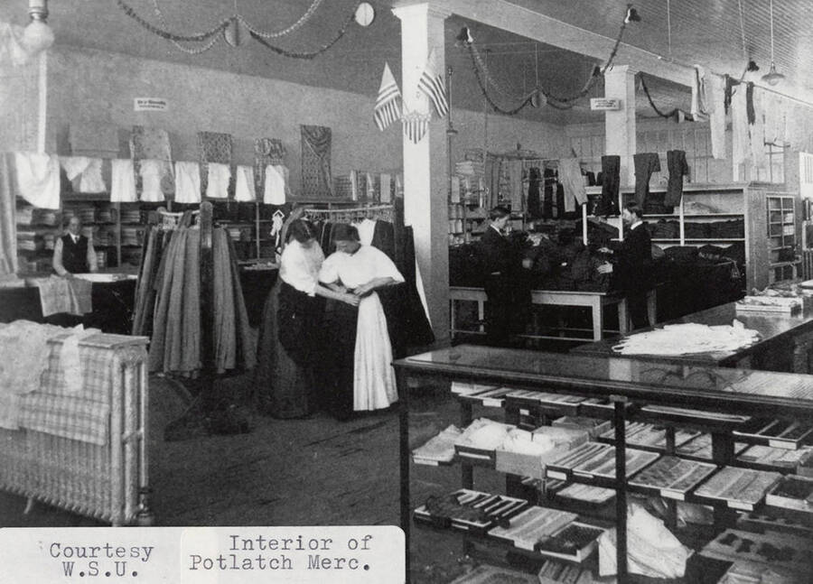 A photograph of the interior of the Potlatch Mercantile Company in the fabric/clothing department.