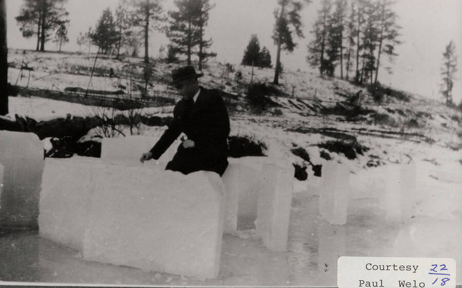 A photograph of a man with several ice blocks.