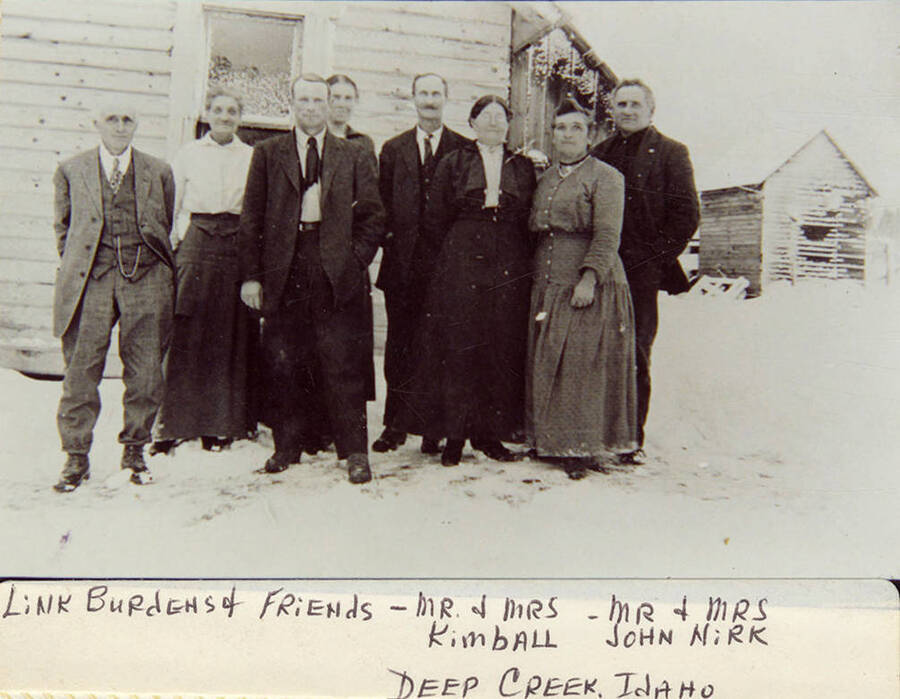 Link Burdeh & friends, including Mr. & Mrs. Kimball and Mr. & Mrs. John Nirk, stand in the snow in front of a house in Deep Creek.