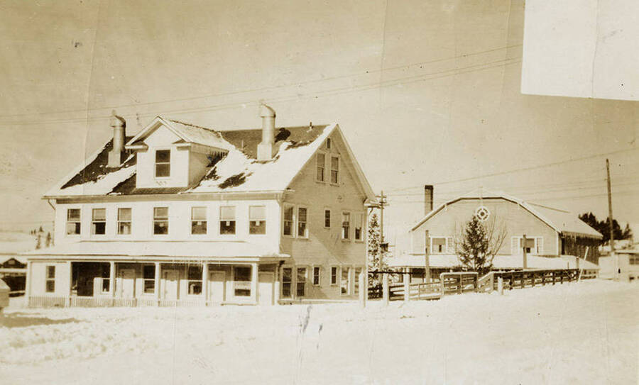 A photograph of the Potlatch Forest Inc. Main Office with the gymnasium in the background.