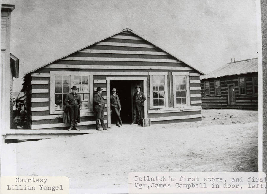 A photograph of the first store in Potlatch, Idaho and it's first manager, James Campbell in the door on the left.