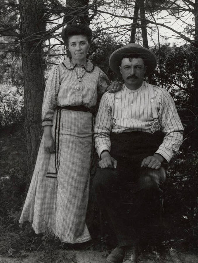 A photograph of a sitting man and standing woman.