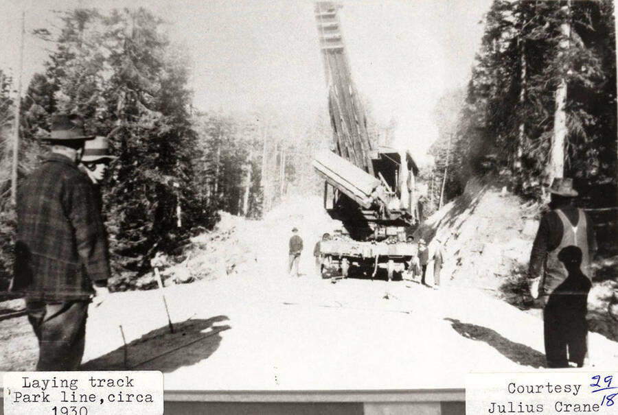Men using a logging spur to lay new track for a railroad.