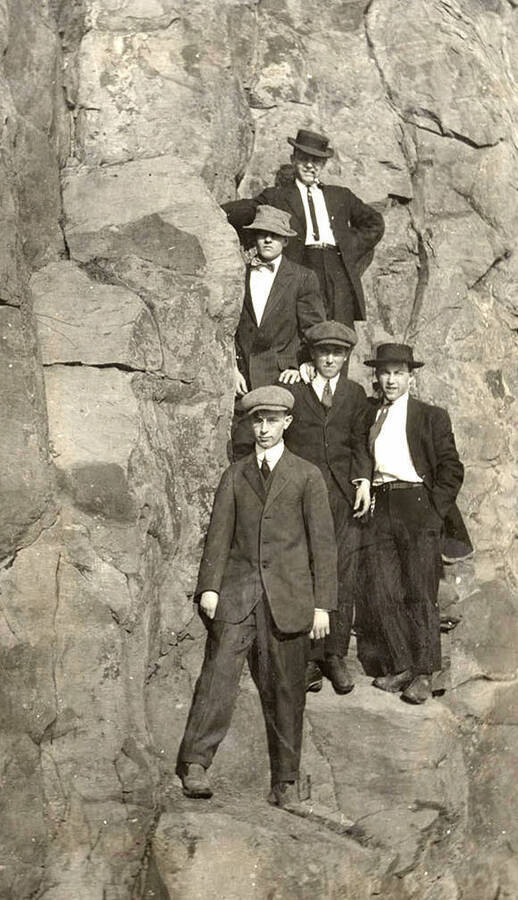 A photograph of five men on rocks.