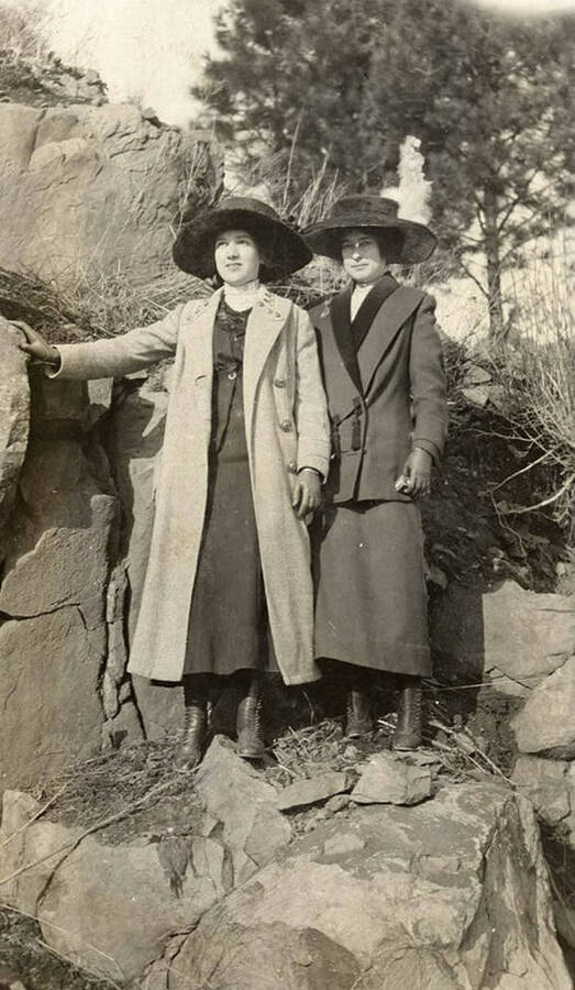 A photograph of two women in the outdoors wearing typical early 18th century clothing.