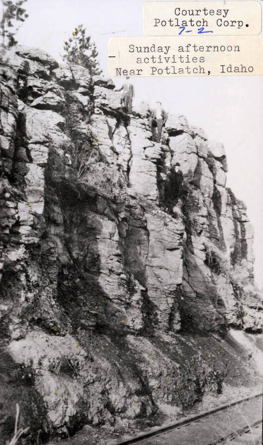 A photograph of three men after they climbed a rock wall on a Sunday afternoon near Potlatch.