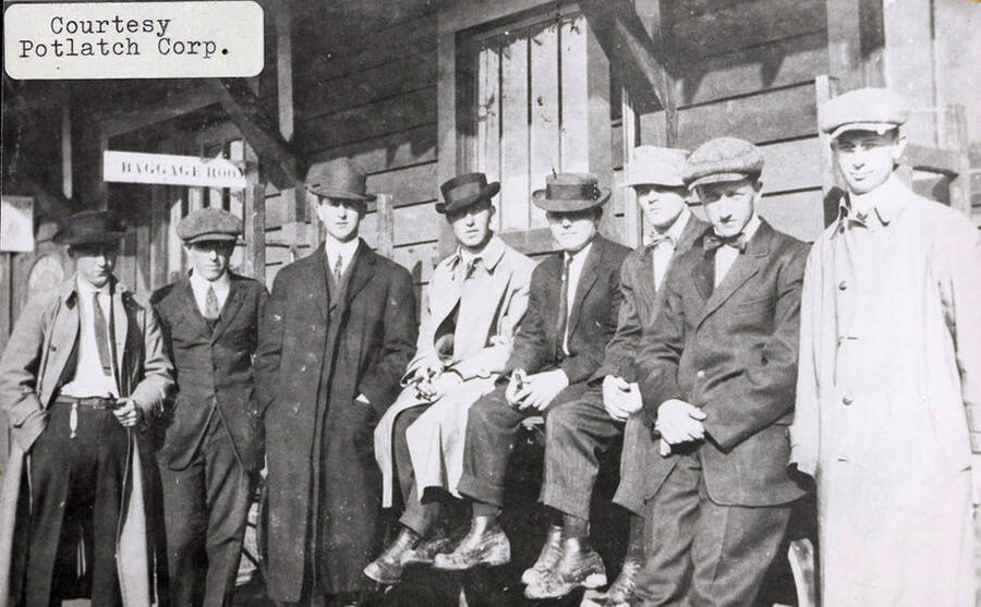 A photograph of eight men in front of the Baggage Room.