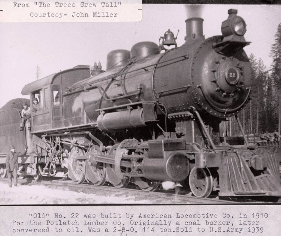 View of an 'old' No. 22 locomotive that was built by the American Locomotive Co. for the Potlatch Lumber Company. The locomotive was originally a coal burner, but was later converted to coil. The locomotive was later sold to the U.S. Army in 1939. A few men can be seen standing on or next to the locomotive.