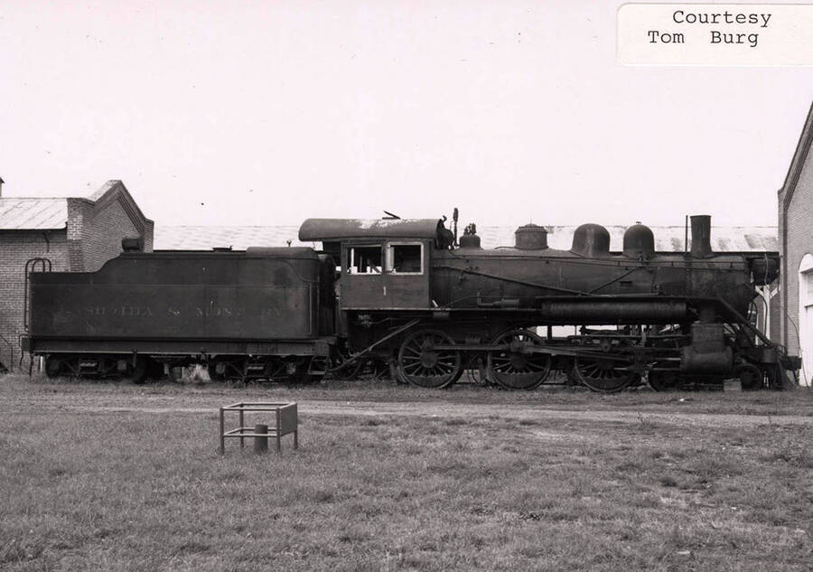 View of a locomotive that can be seen hooked up to a railroad car.