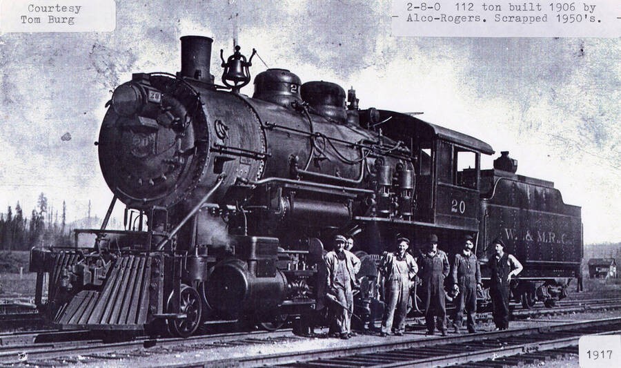 View of a No. 20 locomotive that was built in 1906 by Alco-Rogers and later scrapped in the 1950's. A few men can be seen standing next to the locomotive.