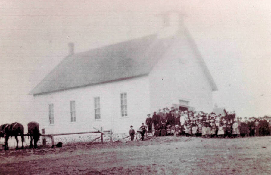 View of Freeze Church, which was built in 1899. A group of people are gathered in the front of the church.