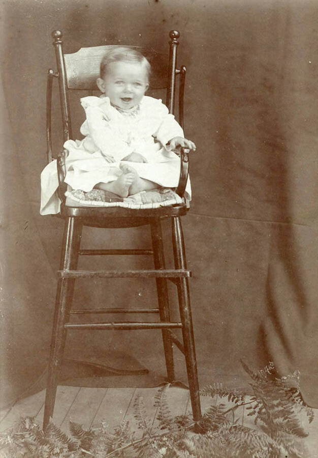 Portrait in a high chair as a baby.