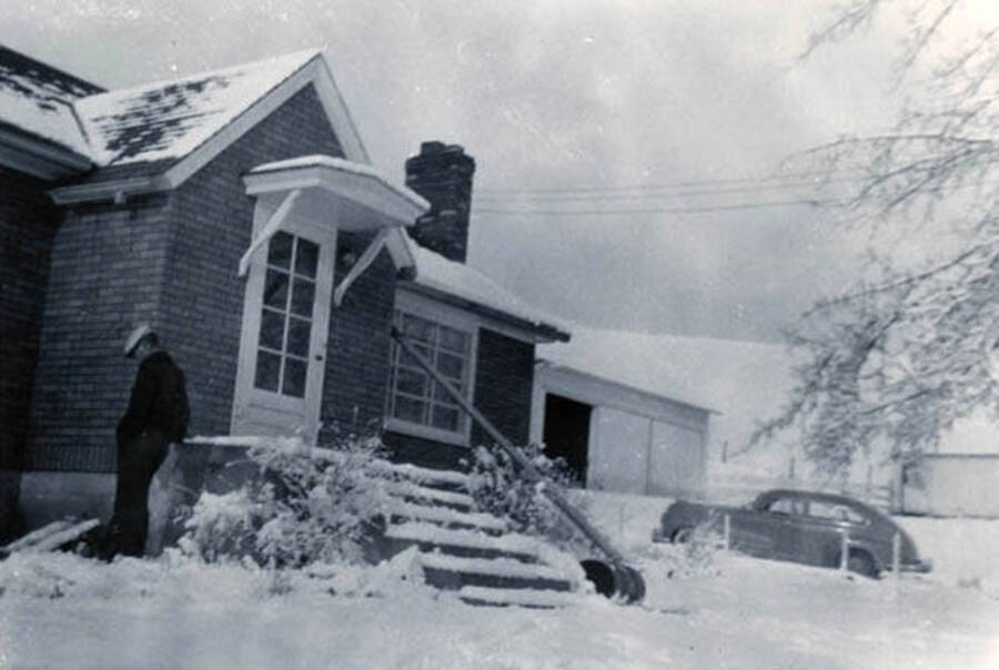 Max Davis standing in front of the W.W. Davis home on a snowy day.