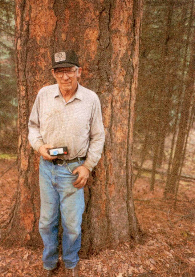 Victor Beplate standing next to a tree trunk at Ruke Zimmerman's place.
