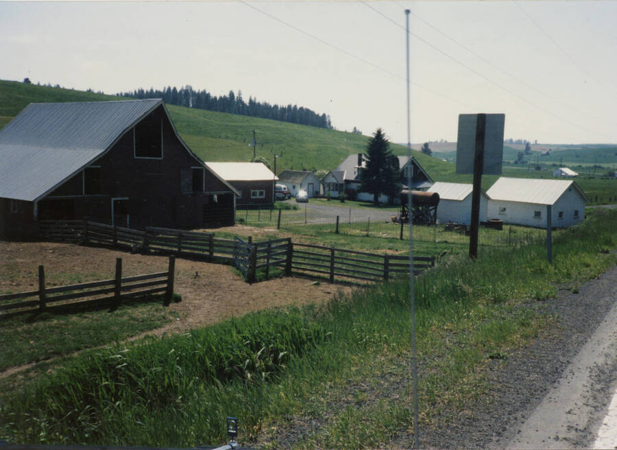 Photo of the Durell Nirk place, taken from the Highway. Can see Barn, outbuildings, house. May 16 1987