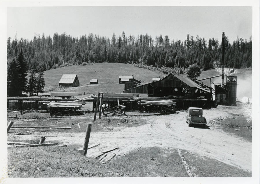 Photo of D. I. Nirk Lumber Co. Old Hall place in background. Houses in center (behind mill) where family lived. The red barn (rear left) still stands in 1990.