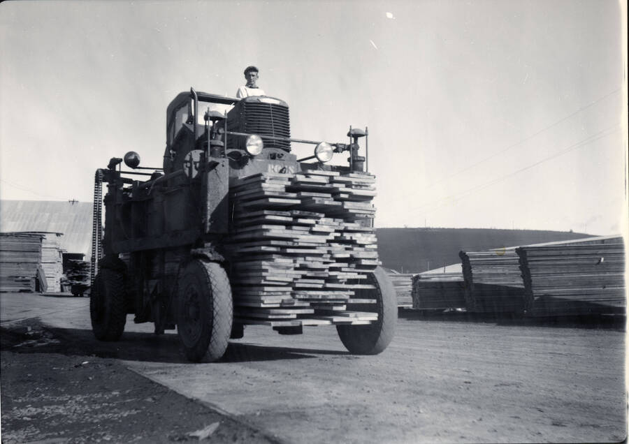 A man operates a straddlebug at the Potlatch mill.