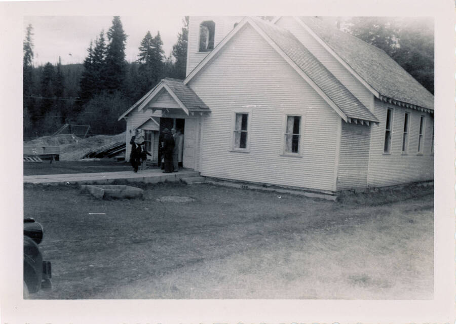 A group of people stand at the entrance to the Elmore Church.