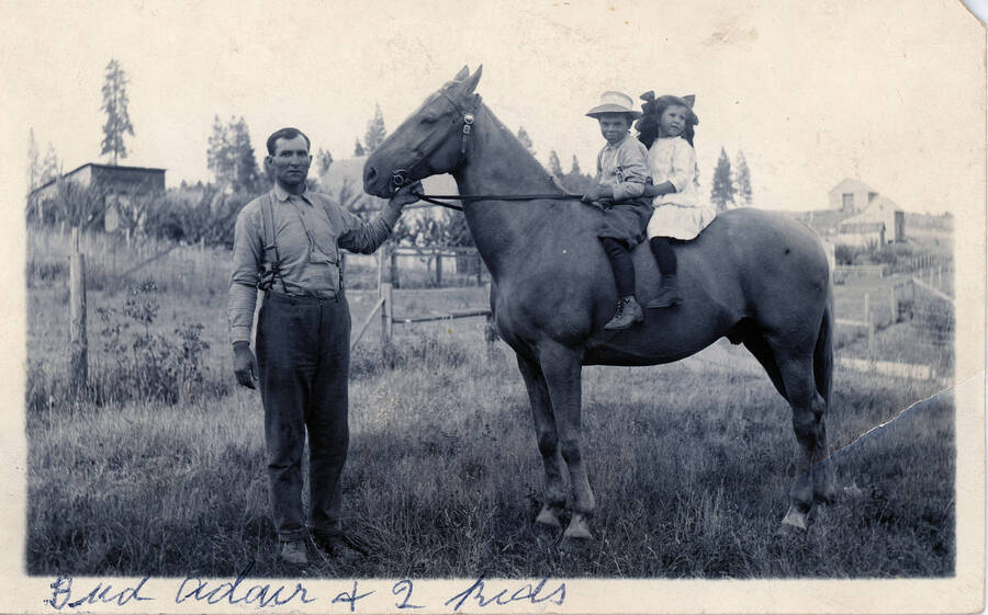 Bud Adair with children on horseback.