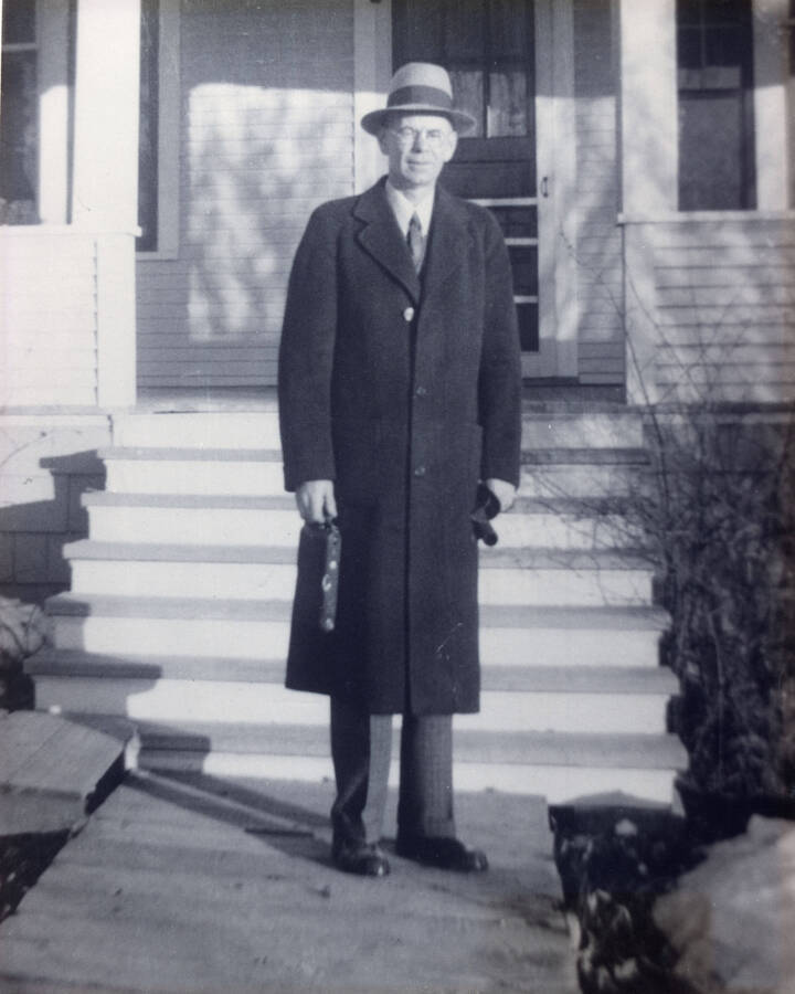 A photograph of Homer L. Peterson in front of his home.  He was Superintendent of Schools in Potlatch, Idaho in the 1920s and 30s.
