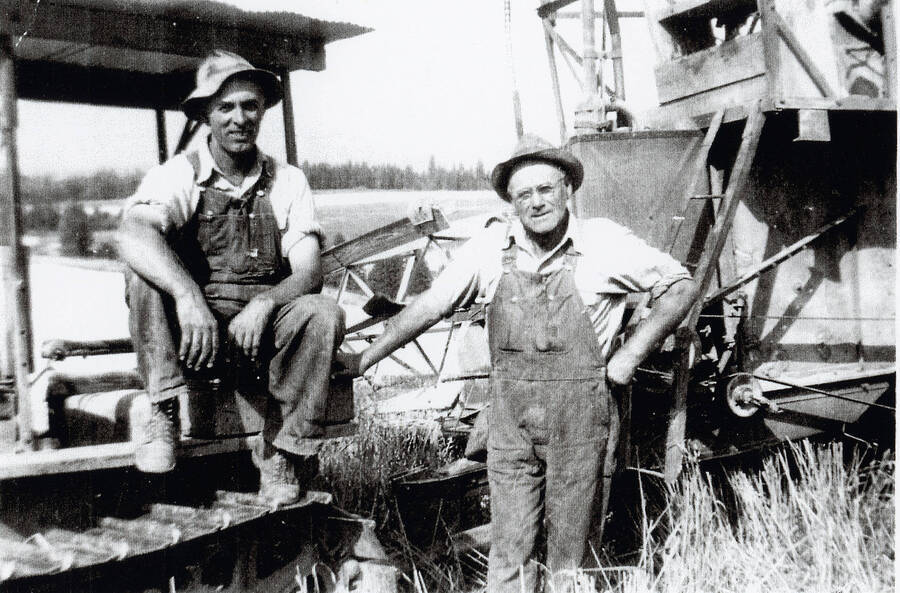 Murry Benjamin and Art Rice on the Benjamin place in front of farm equipment.