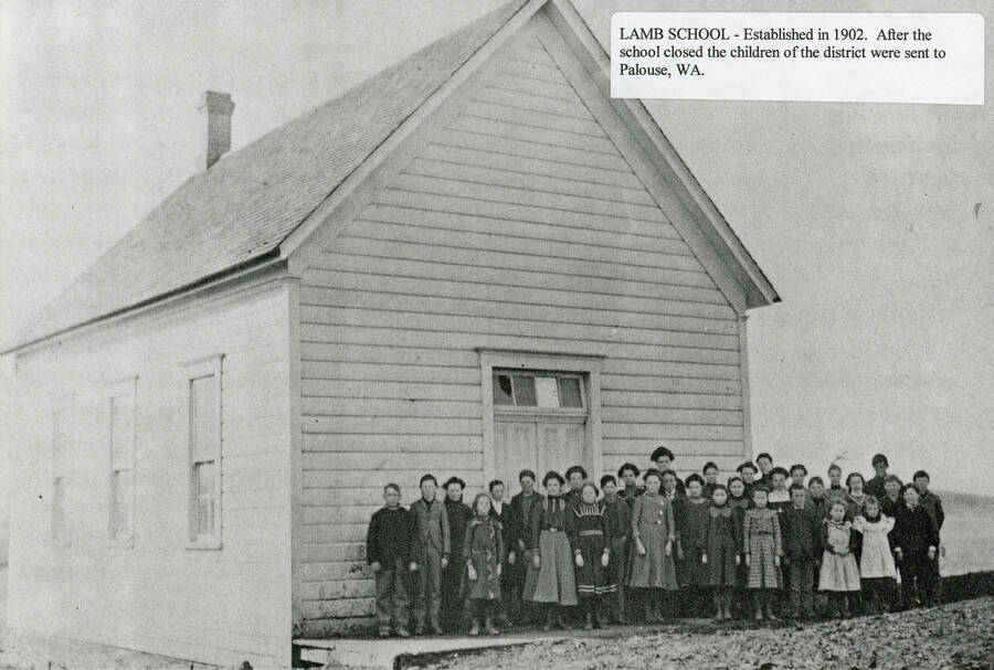 Students at the Lamb School. John and Addie Freeze sold one acre of land to the school in December 1903 for $35. The school closed in the late 1930s and was moved to a nearby farm for storage. Student names are included but not attached to each specific student: Verna Comstock, Lillie Leister (teacher), Paul Anderson, Jr., Rex Nagle, Nagle girls.