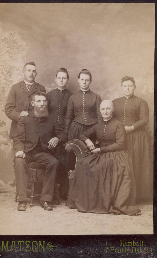 A formal portrait of the Gibbs family taken in Kimball, South Dakota. Family members include: Dan Gibbs, Almira Marsh Gibbs, Frank Gibbs, Mabel Gibbs, Myra Gibbs, and Bertha Gibbs.