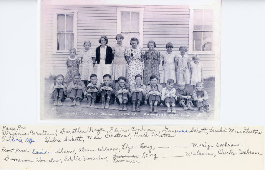 A class photo of the students at Chambers Flat Grade School. In the back row: Virginia Carstens, Dorothea Hagen, Elaine Cochrane, Genevieve Schott, teacher Miss Heaton (?), Patricia Olfs, Helen Schott, Mae Carstens, Ruth Carstens. Front row: Ernie Wilson, Alvin Wilson, Lyle Long, unknown, Marlyn Cochrane, Donavon Vowels, Eddie Vowels, Lawrence Long, unknown Wilson, and Charles Cochrane. 