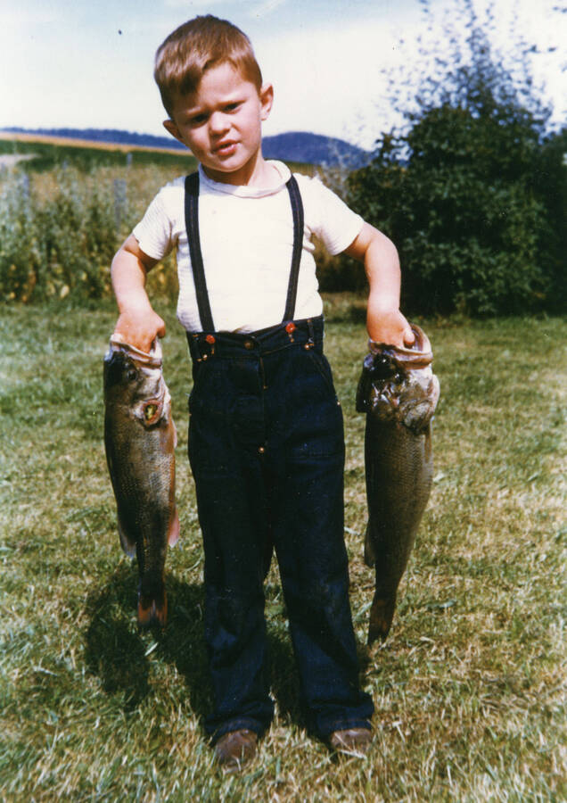 Photograph of Gary E. Strong posing with two fish.