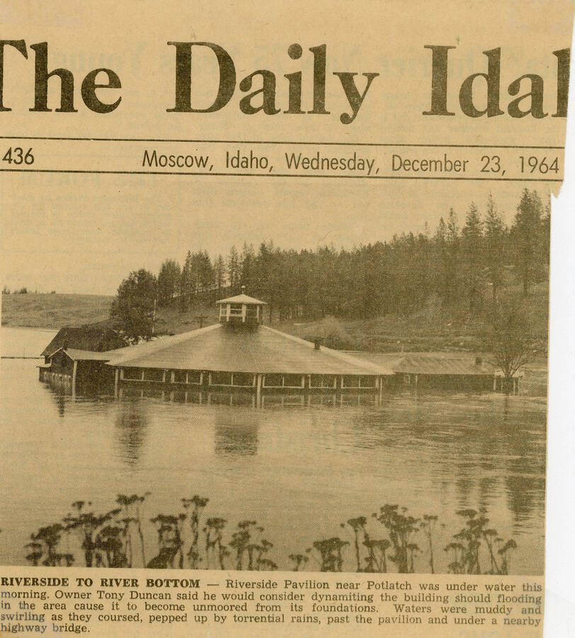 A front page news clipping from The Daily Idahonian that includes a photograph of a completely flooded Riverside Park. The image shows the Pavillion more than 50% submerged in water.