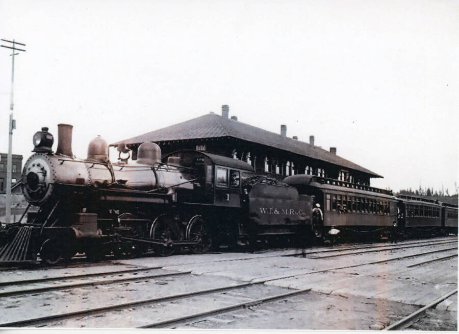 Photograph of Locomotive Number One and passenger cars stopped at the WI&M Depot in Potlatch.