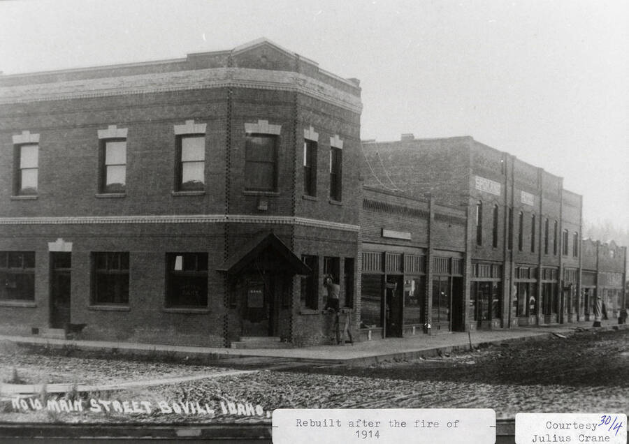 View of Main Street in Bovill after it was rebuilt after the fire of 1914. A person can be seen working on the window of a building.