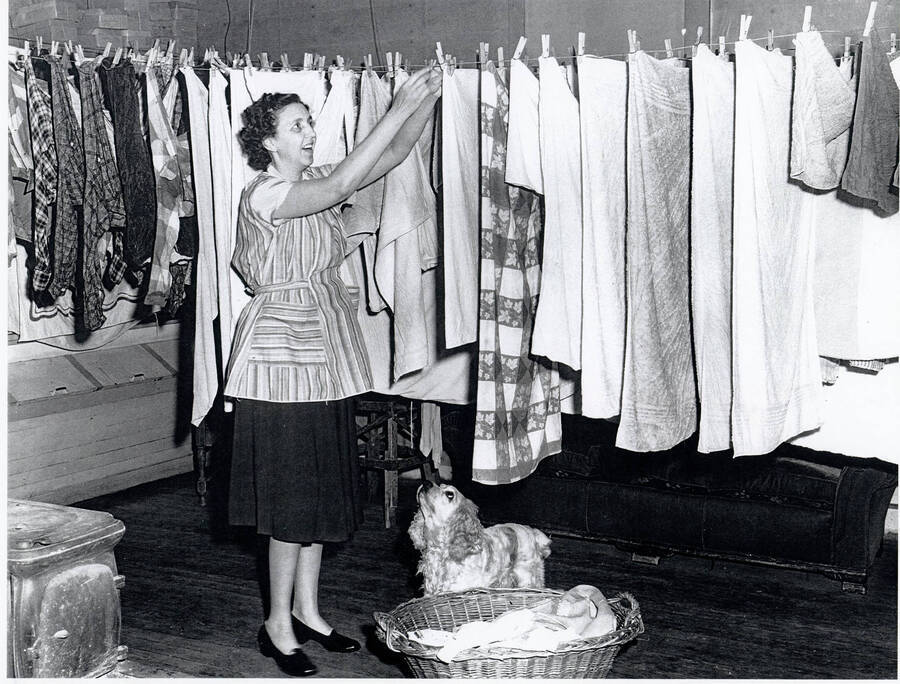 Photograph of Margaret Bull hanging laundry in the Princeton Post Office after hours during the winter.