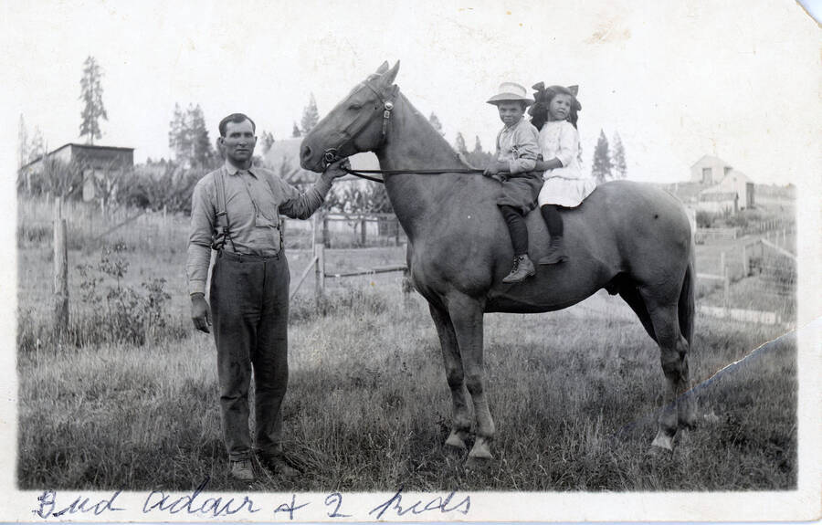 Postcard of Bud Adair with his children on a horse.