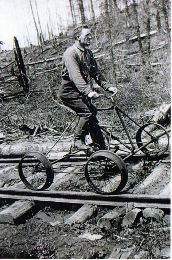 Photograph of a rail bike rider in the woods on the tracks of the WI&M railway.