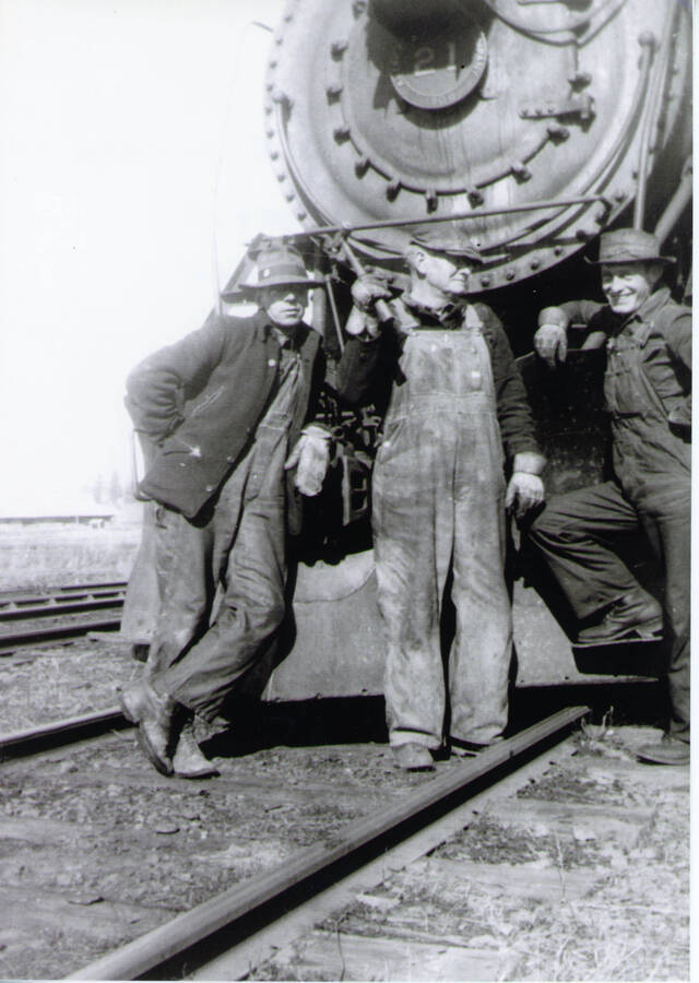 Photograph of Charlie Trotter, Elmer Helm, and Rex Benson in front of Locomotive #21.