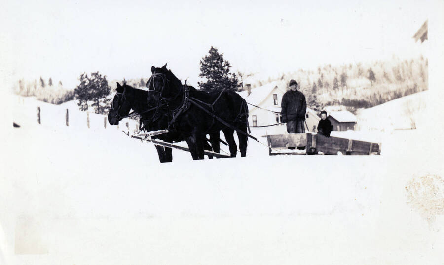 Photograph of John Bysegger with John Jr. breaking roads in winter.