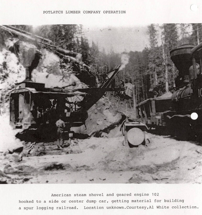 An American steam shovel and a geared engine 102 hooked to a dump car. The equipment is being used to get material for building a spur on the logging railroad. A man can be seen standing next to the steam shovel.