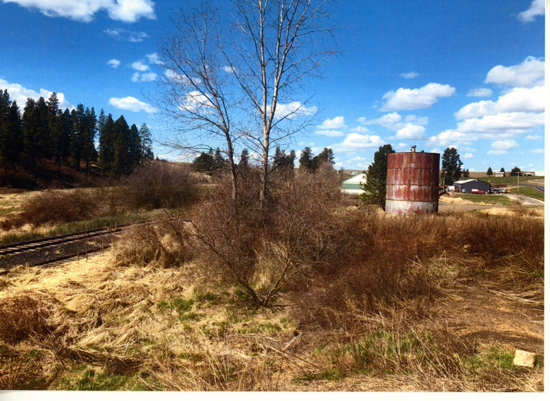 Photograph of the water tower at Kennedy Ford with shop buildings in the background.